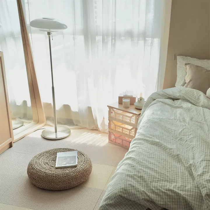 Warm bedroom with a neutral TOLI modular carpet tile rug beside the bed